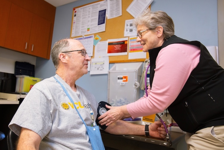 Provider takes male patient’s blood pressure
