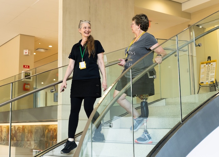 Wendy walks down the stairs with a fellow volunteer Diana