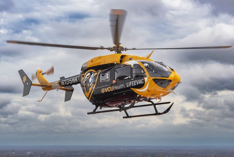 VCU Health helicopter in hovers above the city of Richmond.