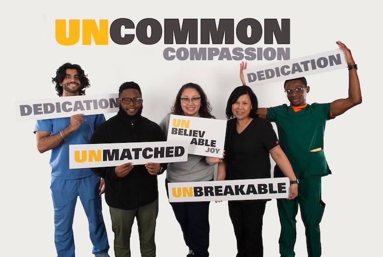 VCU Health team members hold up signs with different words on them