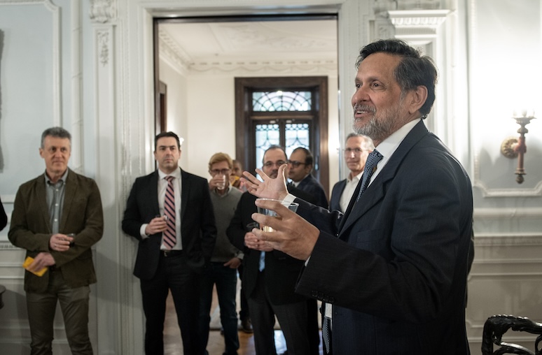 Man stands speaking to a group.