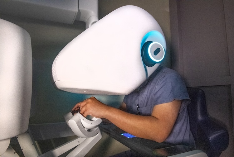 Man using robotic device to operate on patient