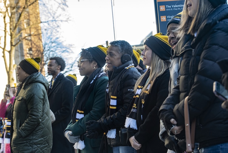Group of people with VCU Health hats stand on the street