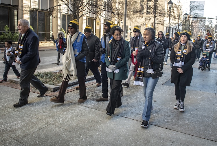 People with VCU Health hats walking on the sidewalk