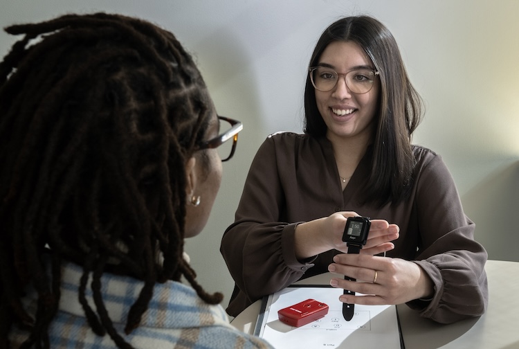Two women look at a mobility tracker device