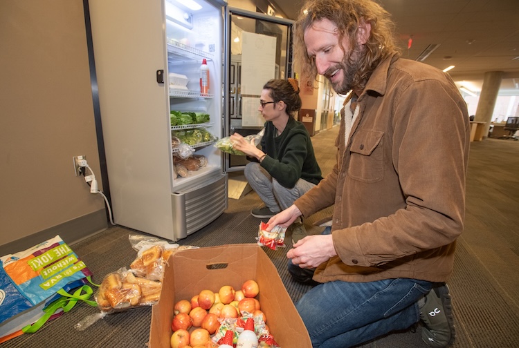 John Jones stocking food in fridge