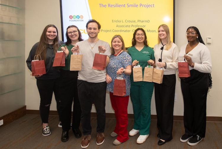 Group of volunteers holding dental kits in hands