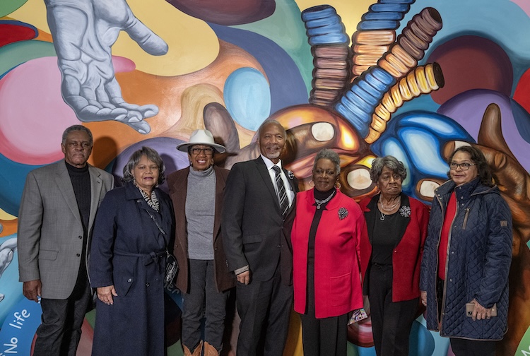 Group of people standing in front of mural painting