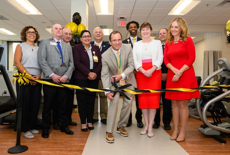 VCU Health leadership stand around Dr. Greg Hundley, director of the Pauley Heart Center, as he cuts the ribbon on the new clinic at VCU Health Reynolds Crossing.