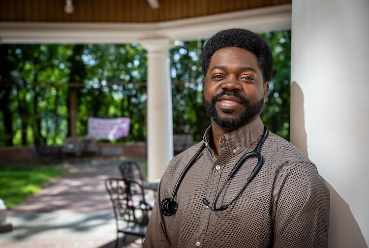 Devon Jones wearing a plaid button-up with stethoscope around his neck.