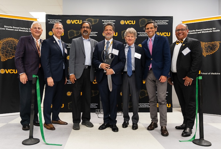 VCU and VCU Health leaders stand together at a ribbon cutting