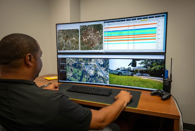 Man looking at a computer screen to dispatch the AED to location.