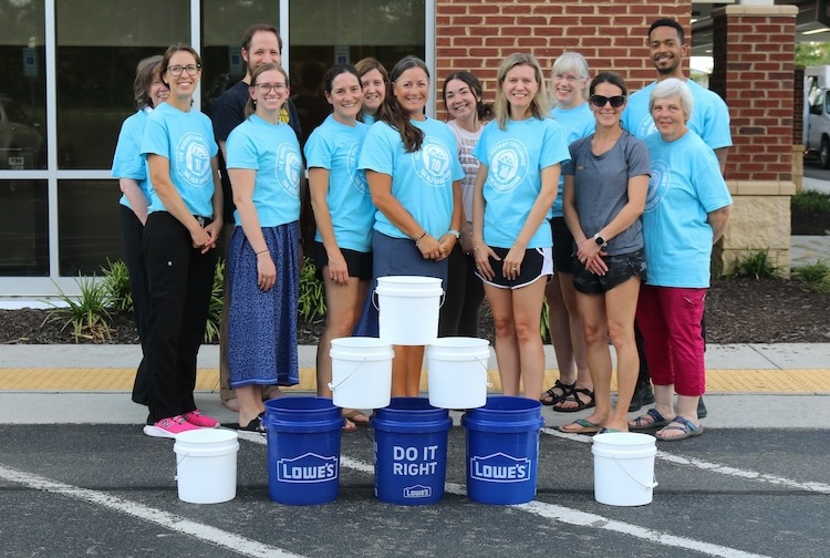 Group of people in matching blue shirts standing together 