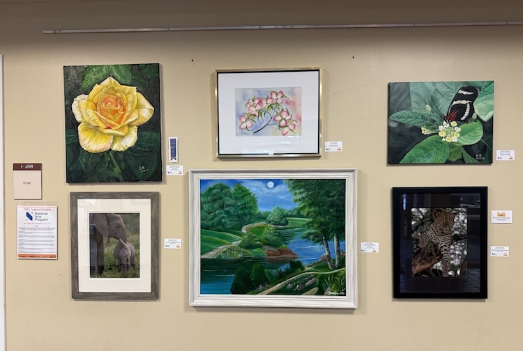 Six pieces of artwork are displayed on the wall