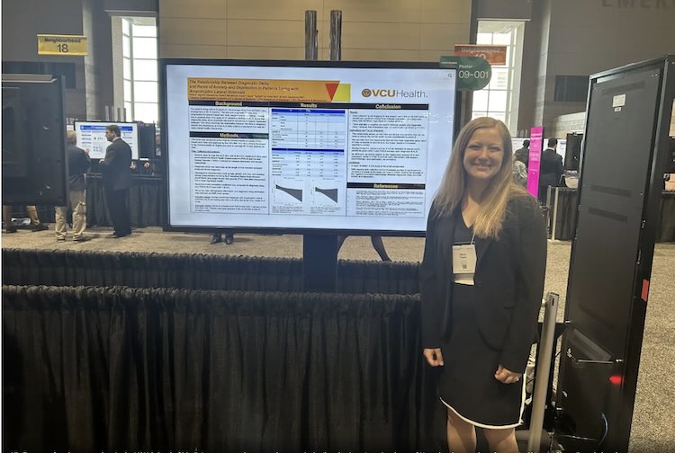 Ally Tegner in front of her research poster at a conference