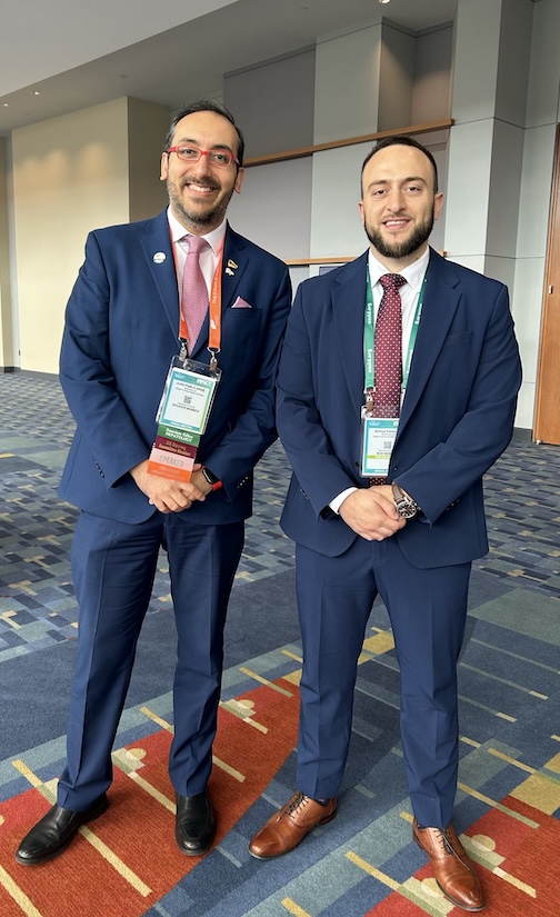 Two men in suits at a conference