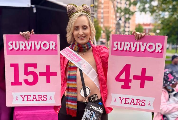Beth Rutherford holding two pink survivor posters
