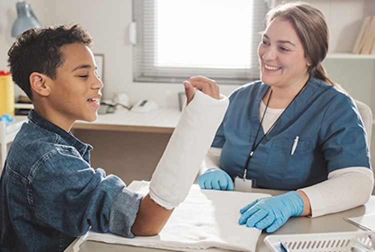 Boy with broken arm talking to nurse