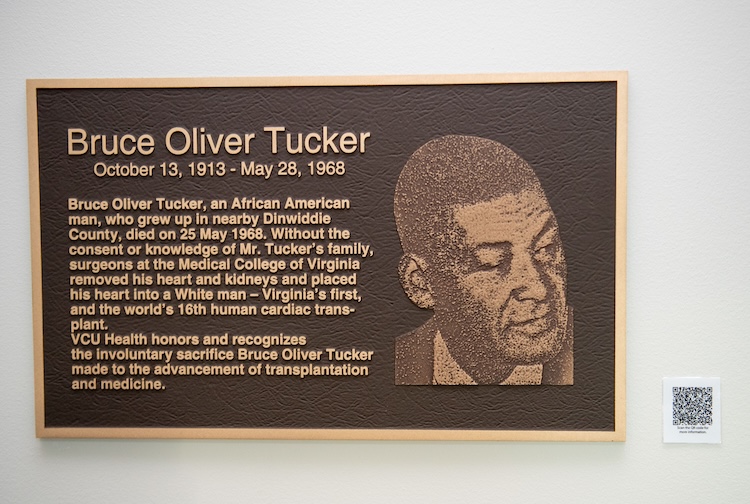 The signage has Bruce Oliver Tucker’s face and a summary of his story.