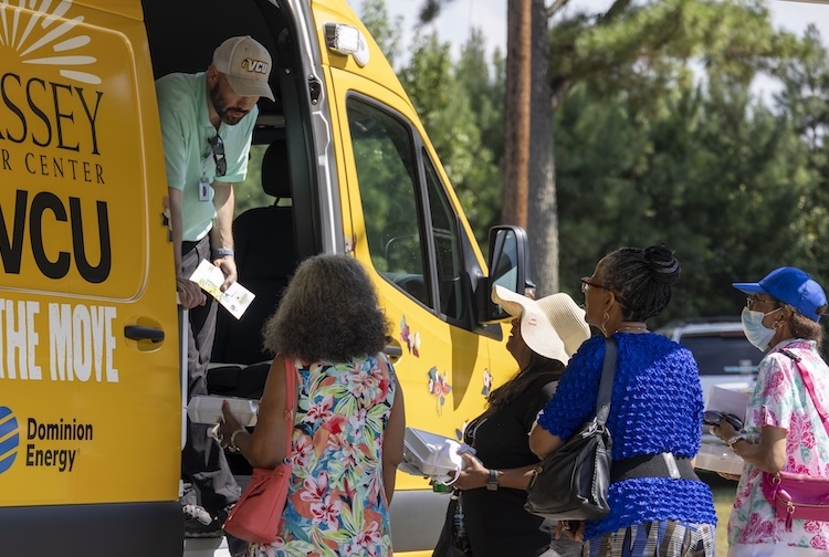 Community members speak with a member of the Massey on the Move team during an event