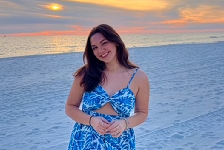 Addison Browell on a beach standing in front of a sunset