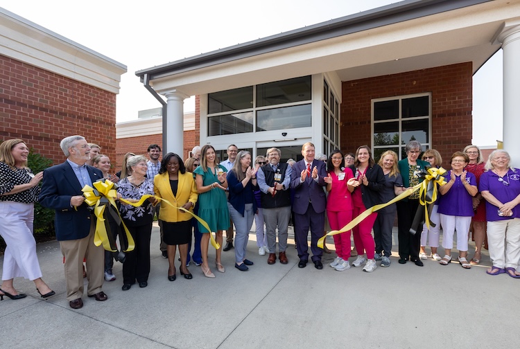 people stand in a row for ribbon cutting