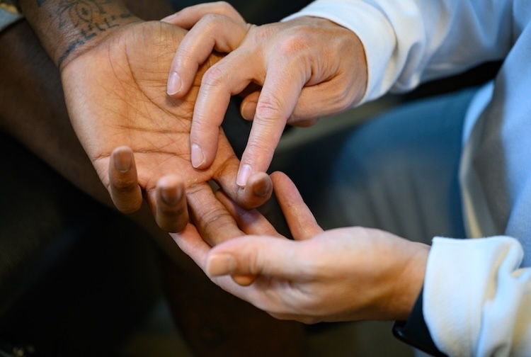 Dr. Cheatham hold’s Joe’s fingers and examines them