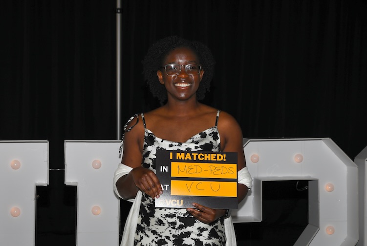 Comfoirt Aluko holding up VCU Matched sign