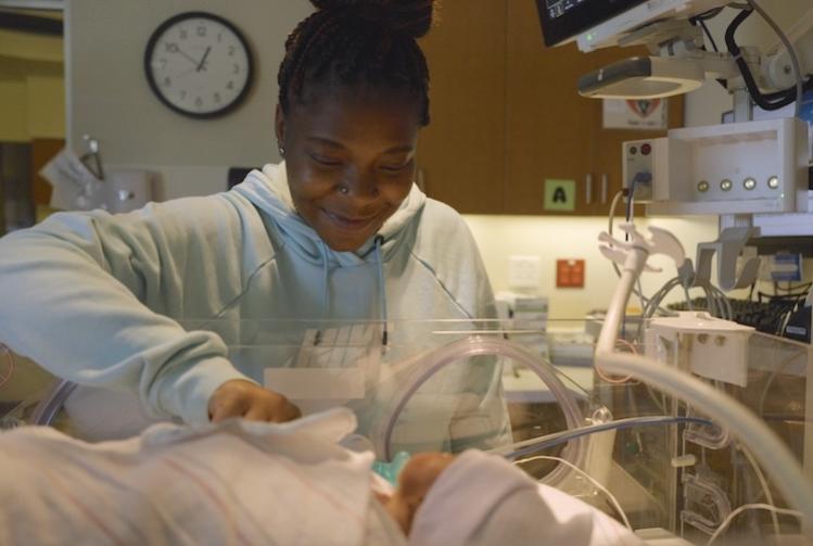 Danielle Hayes looks at her son in the NICU crib