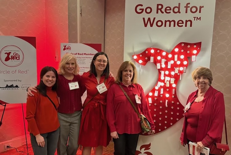 Desiree standing with group of women at a Go Red for Women event. They are all wearing red clothing