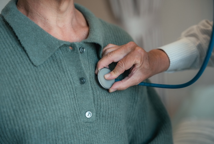 Doctor performing a clinical assessment using a stethoscope on a senior patient