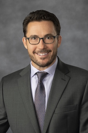 Dr. Berman wears a suit and bowtie