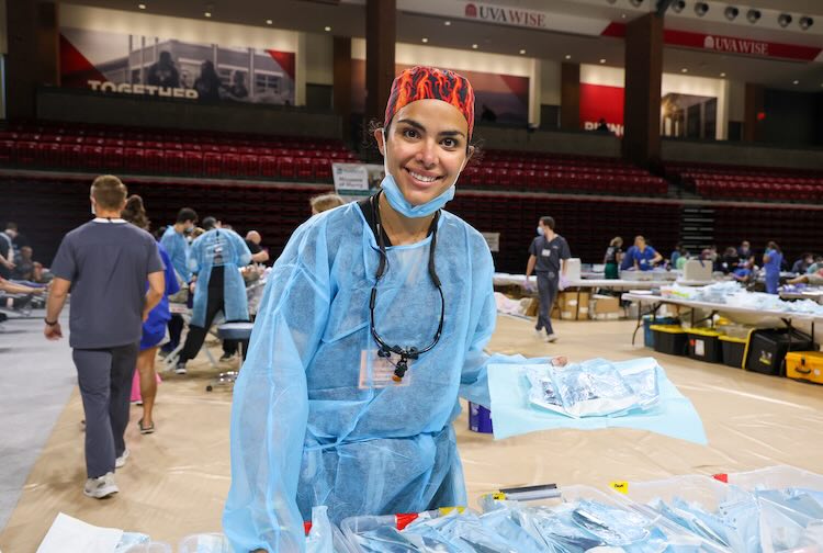 Dr. Khraibut in medical scrubs standing in a stadium at an event