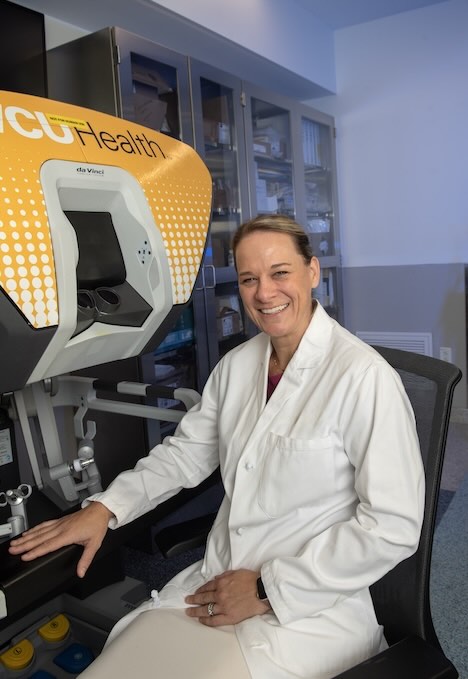 Dr. Czyszczon sits next to a robotic surgery console