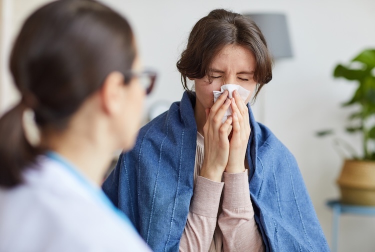 Woman sick with the flu talks to a doctor