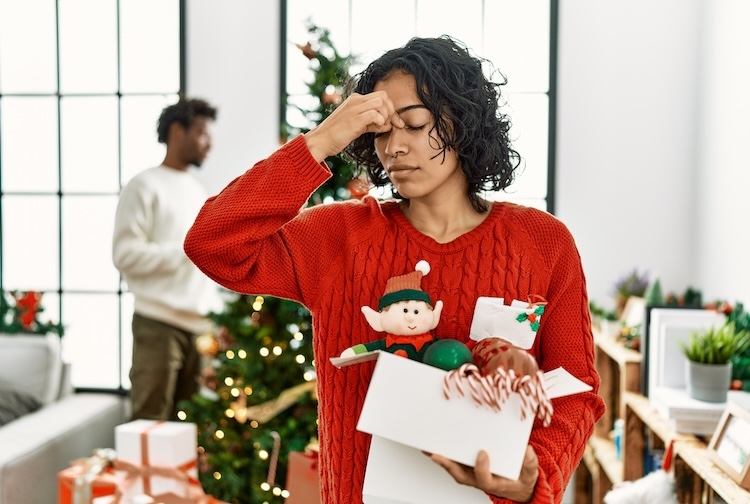 woman standing by Christmas tree stressed out