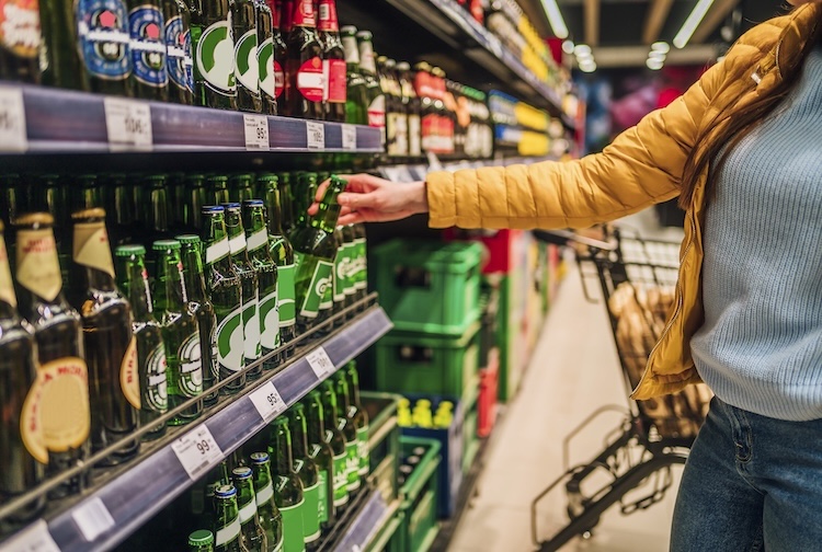 Woman buying beer at a grocery store