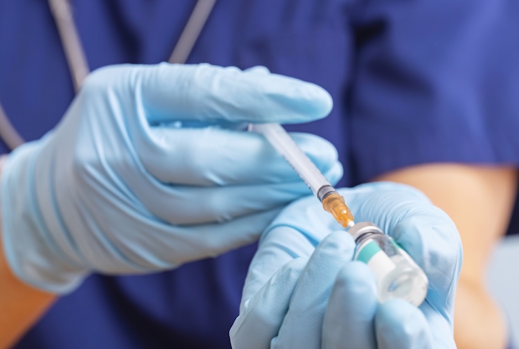 Doctor fills syringe with vaccine
