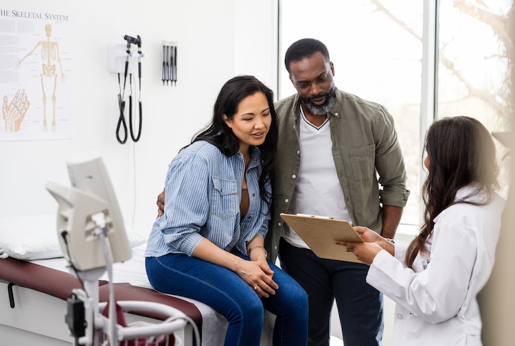 female doctor shows a couple the medical test results
