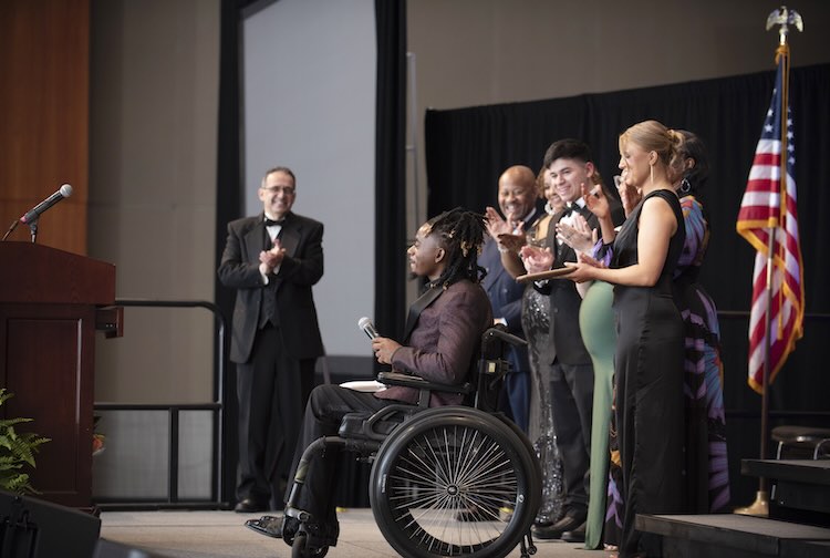 Darrell Anderson on stage with individuals as he receives his award