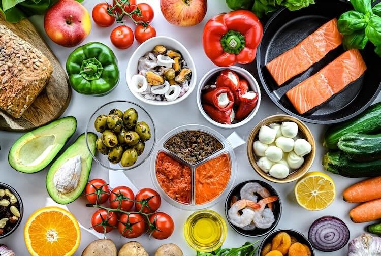 Table set with variety of color fruits, vegetables and meat