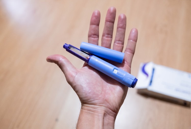 hand holding GLP1 injection pen as a medical treatment for the prevention and control of overweight and obesity.