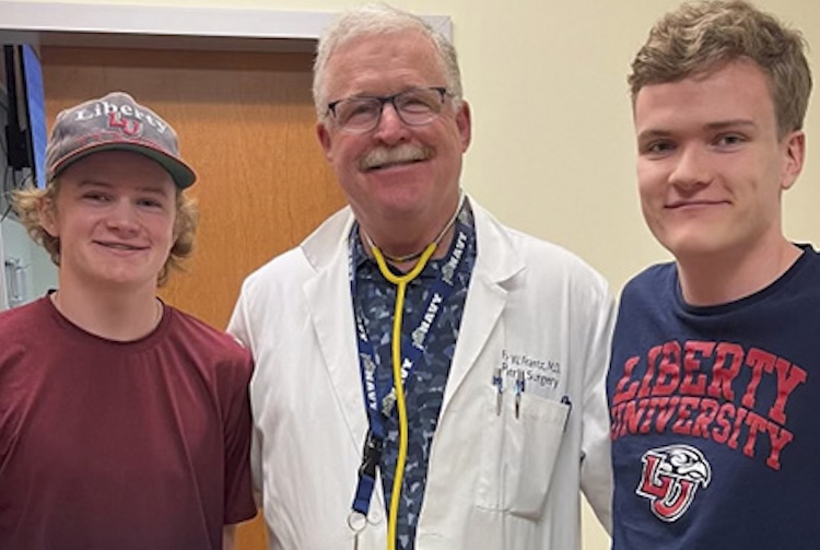 Two brothers who had chest wall surgery stand with their surgeon