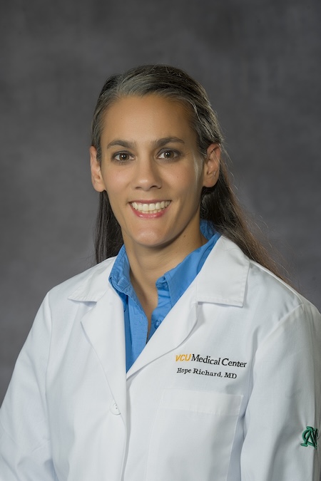 Dr. Richard wearing a blue blouse along with her VCU Health white coat.