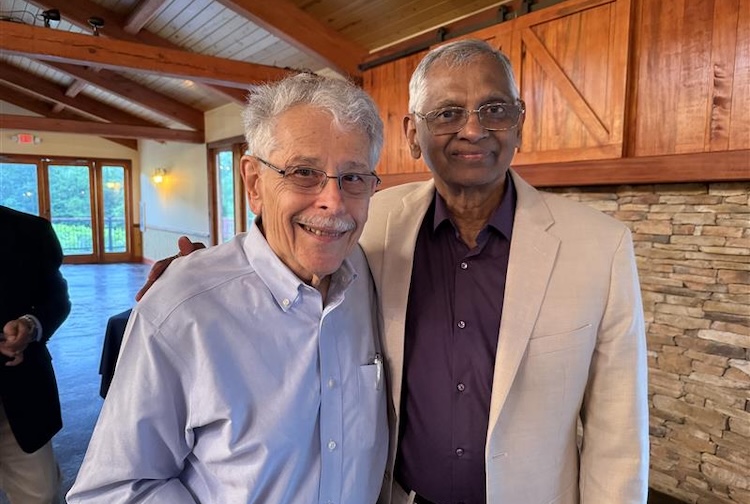 Two doctors in button up shirts smiling at a retirement party