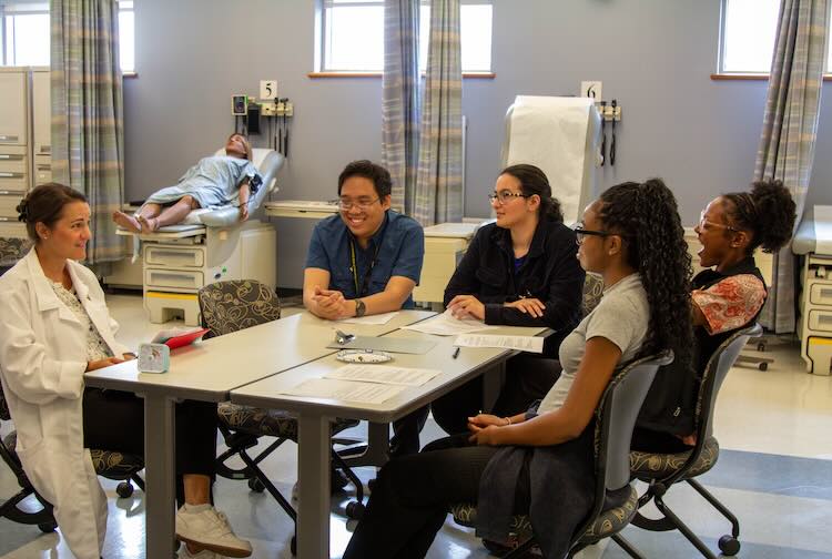 Students sitting around a table debriefing