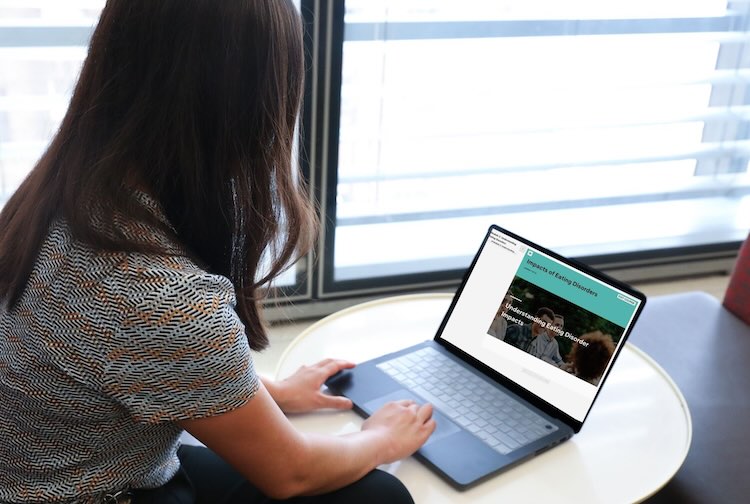 Dr. Wu looking at a presentation on a laptop computer.