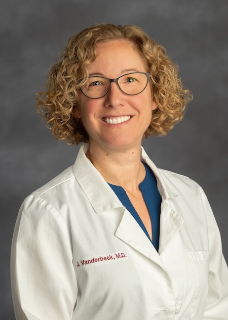 Dr. Vanderbeck wearing a blue blouse along with her VCU Health white coat.
