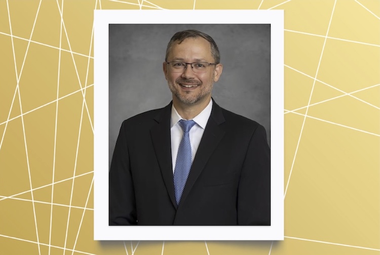 Josh Hammond in a suit with a blue tie