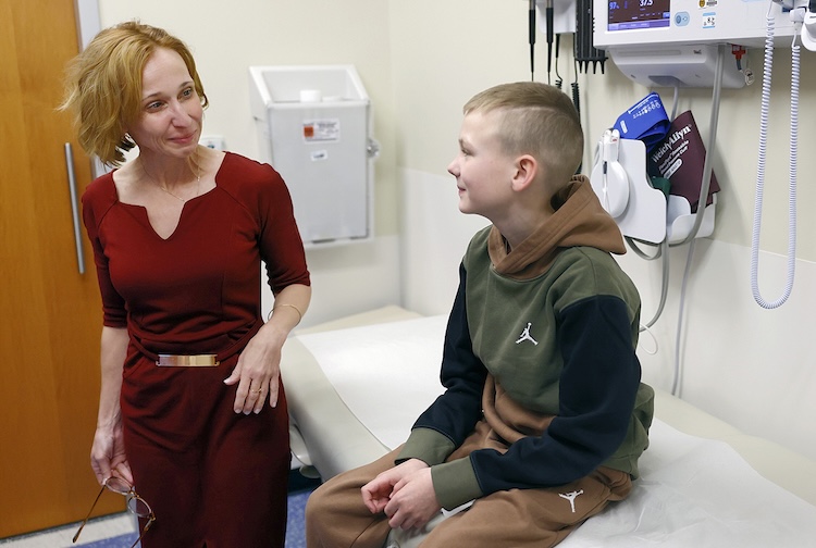 Keegan smiles at Dr. Szabo in a patient room